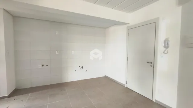 Interior de um ambiente com paredes brancas e piso de concreto.