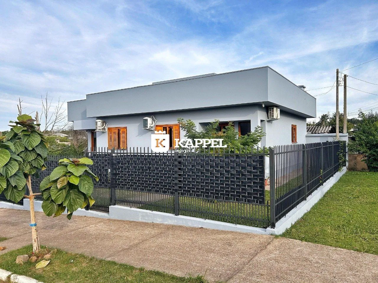 Fachada de uma casa moderna com cerca preta em Lajeado, Brasil.