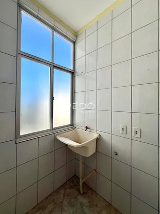 Parede interna com azulejos brancos e uma janela.