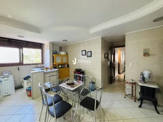 Vista interna de uma sala de jantar com piso de cerâmica e janela em Lajeado.