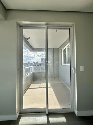 Vista de um apartamento com porta de vidro para uma varanda.