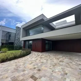 Fachada moderna de uma residência com piso de pedra em Lajeado.