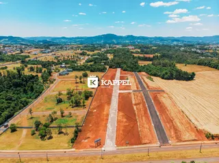 Vista aérea de um terreno rural com áreas de vegetação e campos abertos.