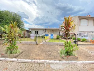 Fachada de uma casa em Lajeado, Brasil com jardim frontal e cerca.