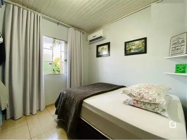 Quarto com cama e janela em ambiente interno.