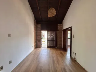 Hall de entrada com piso de madeira e teto de madeira exposta.
