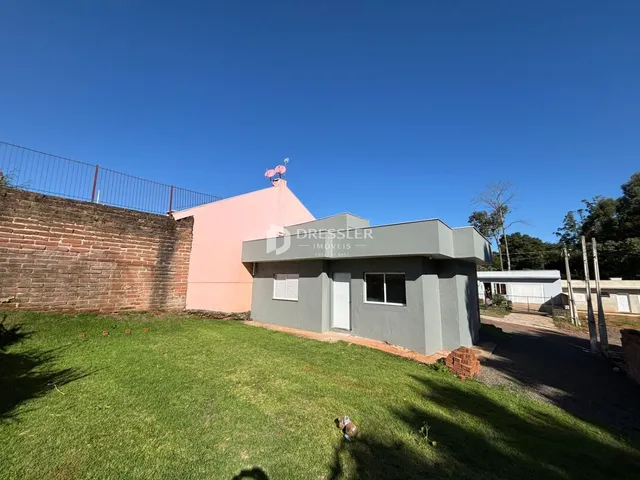 Vista externa de uma casa em Lajeado, Brasil, com muro de tijolos e gramado.