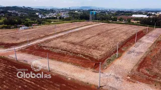 Campo aberto de terra com estradas de terra e cerca delimitando a propriedade.