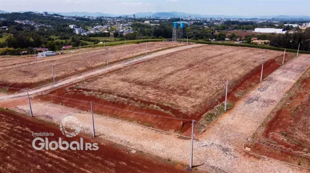 Campo aberto de terra com estradas de terra e cerca delimitando a propriedade.