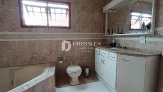 Banheiro com janela e revestimento de cerâmica.