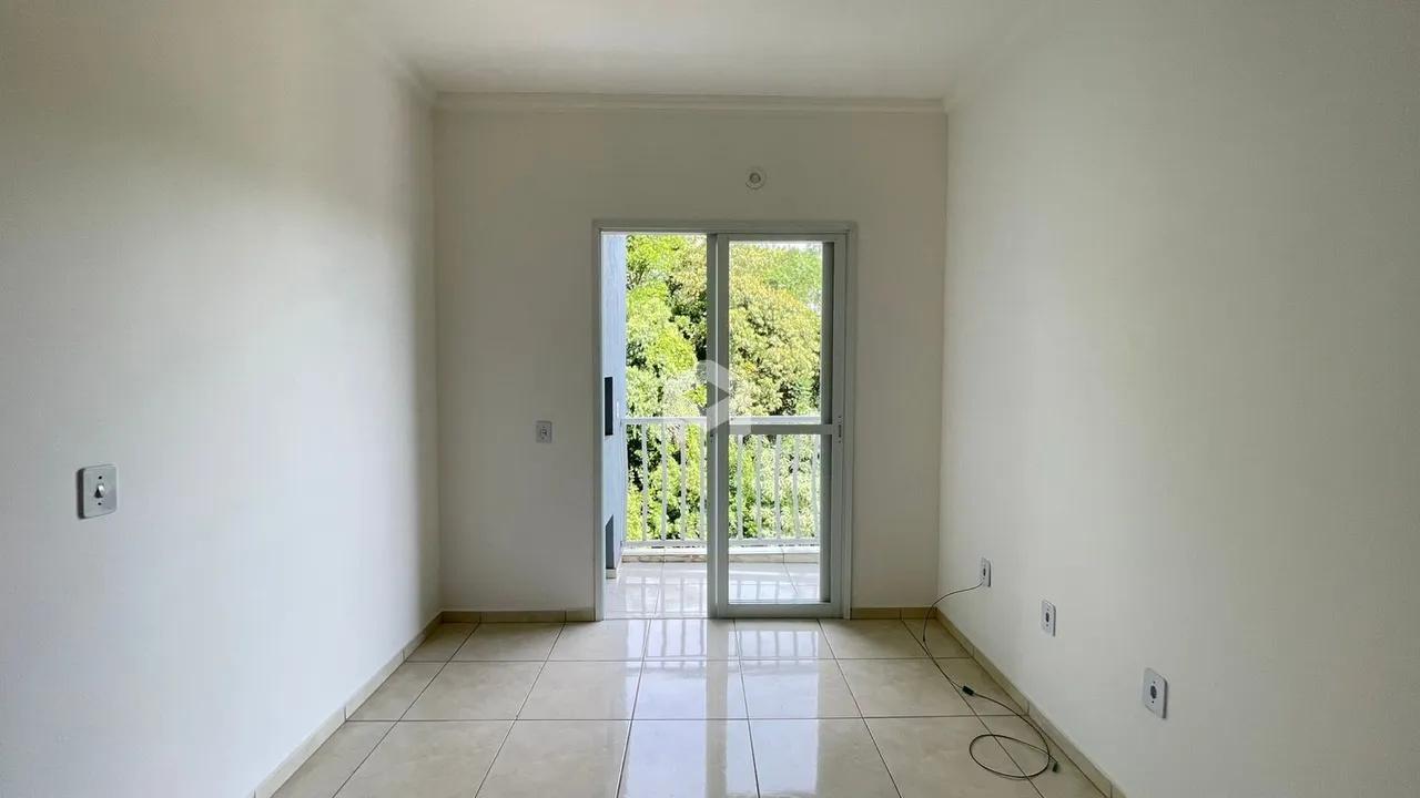 Ambiente interno com piso de cerâmica e porta de vidro que dá para o exterior.