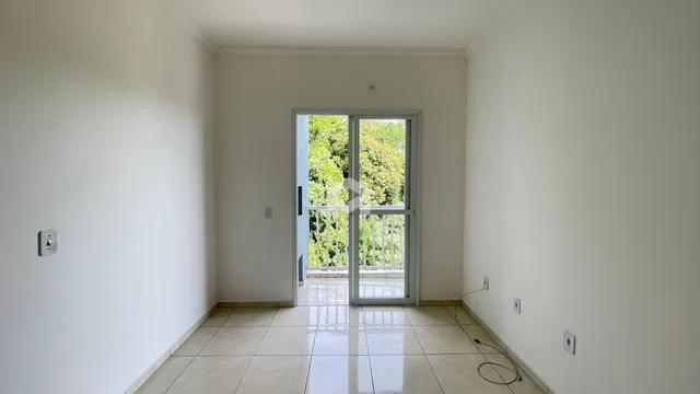 Ambiente interno com piso de cerâmica e porta de vidro que dá para o exterior.