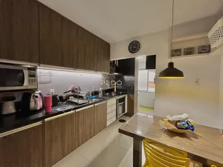 Foto de uma cozinha com armários de madeira e bancadas escuras.