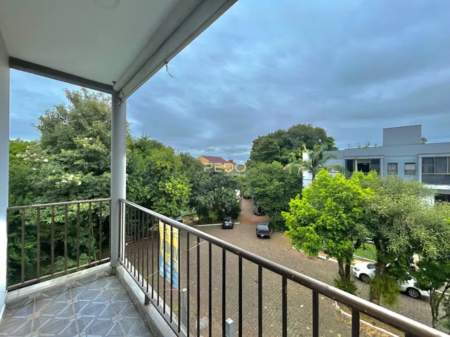 Vista de uma varanda com grade de ferro sobre uma área externa.