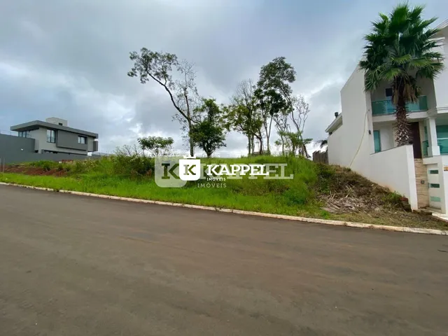 Vista externa de uma residência branca em Lajeado com vegetação ao fundo.