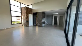 Sala ampla com piso de porcelanato e grandes janelas em ambiente interno.