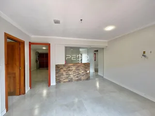 Sala de estar com piso claro e parede de destaque na residência.