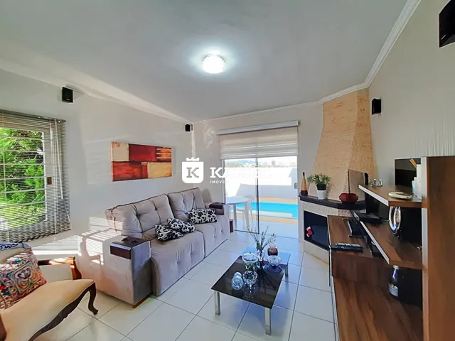 Sala de estar com sofá e vista para o exterior em um imóvel em Lajeado.