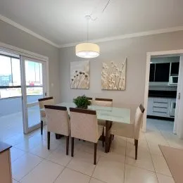 Sala de jantar com mesa e portas de vidro.