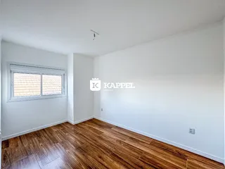Ambiente interno com piso de madeira e janela em sala.