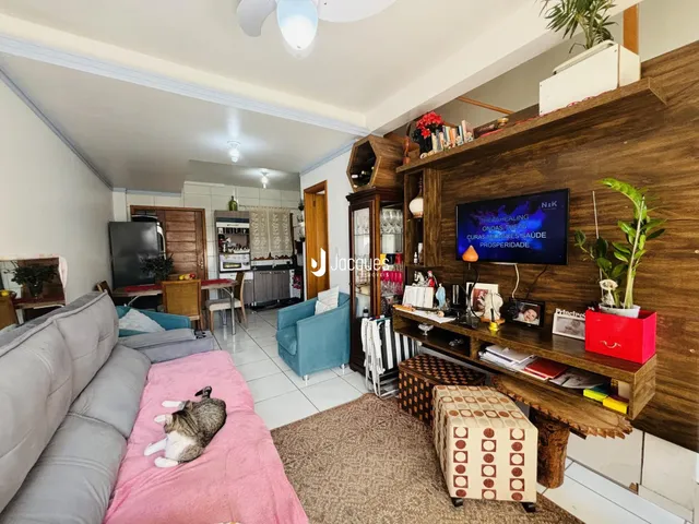 Sala de estar com sofá e área de jantar em imóvel no Brasil.