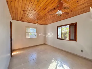 Ambiente interno com piso de cerâmica e teto de madeira.
