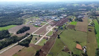 Vista aérea de uma área rural com campos e vegetação no Brasil.