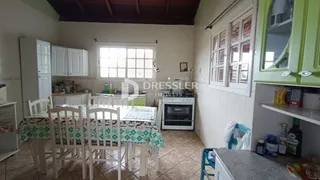 Ambiente interno de uma sala com mesa de jantar e armários brancos.