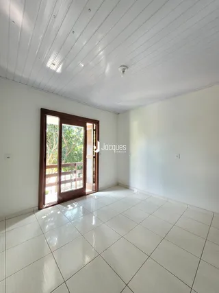 Interior de uma sala com piso de cerâmica e porta de vidro.