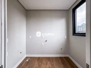 Foto de um corredor interno com piso de madeira e janela mostrando um prédio na Lajeado.