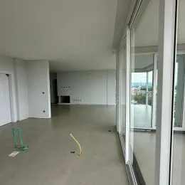 Corredor interno com paredes brancas e piso claro.