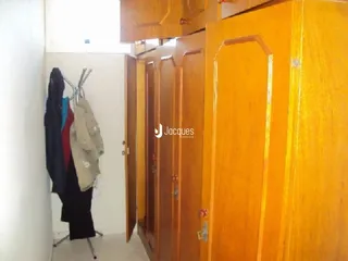 Um corredor interno com portas de madeira marrom.