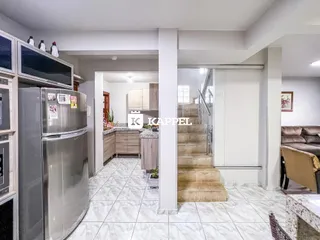 Ambiente interno com cozinha e acesso a escadas em um imóvel.