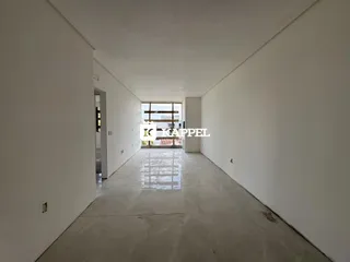 Corredor interno de uma residência com paredes brancas e piso claro.