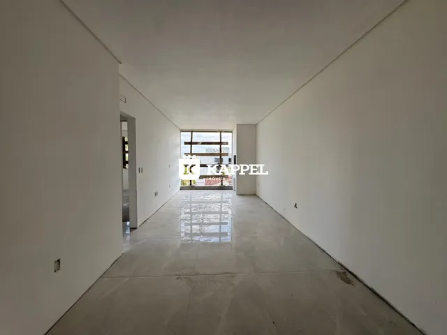 Corredor interno de uma residência com paredes brancas e piso claro.