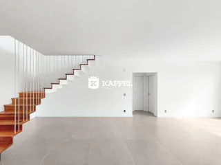 Foto de um ambiente interno amplo com escadaria e piso de cerâmica.