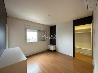 Ambiente interno de uma sala com piso de madeira clara e janela.