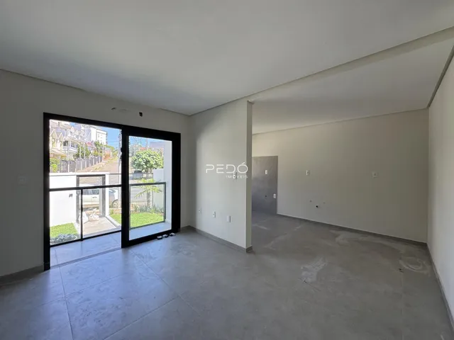 Sala de estar com porta de vidro abrindo para o exterior.