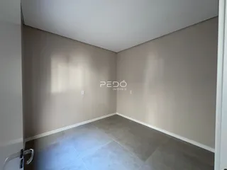 Vista interna de um ambiente com piso de cerâmica e paredes claras.