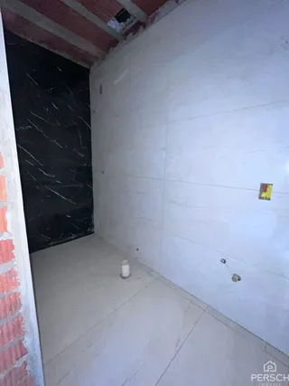 Foto de um corredor interno com paredes brancas e piso claro.