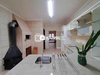 Cozinha com bancada clara e exaustor preto em ambiente residencial.