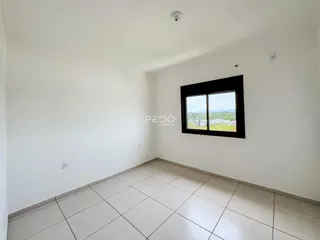 Ambiente interno de uma sala com piso de cerâmica e janela.