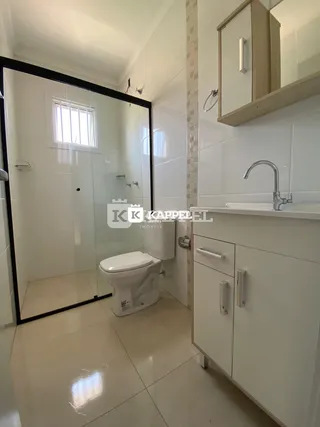 Foto de um banheiro com piso de cerâmica e bancada branca.