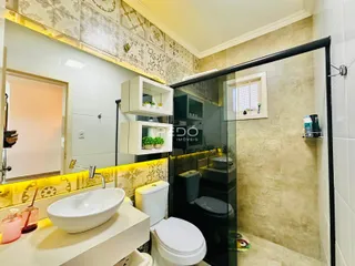 Foto de um banheiro com azulejos e box de vidro em um imóvel no Brasil.