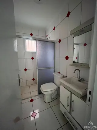 Foto interna de um banheiro com revestimento de azulejos brancos e piso claro.