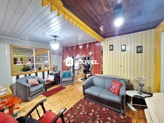 Sala de estar com piso de madeira e móveis estofados.