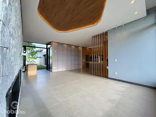 Ambiente interno amplo com teto arqueado e paredes em tom neutro.
