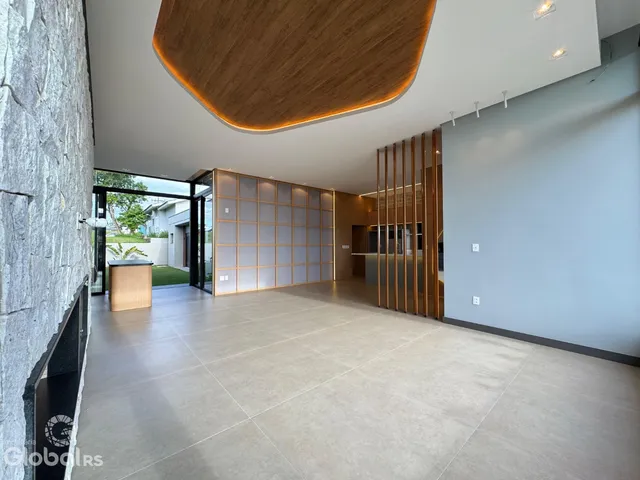 Ambiente interno amplo com teto arqueado e paredes em tom neutro.