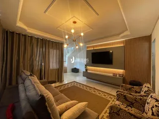 Sala de estar moderna com sofás e decoração de parede em Lajeado.