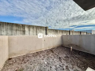 Vista de um lote vazio com terra e muro de concreto em Lajeado.